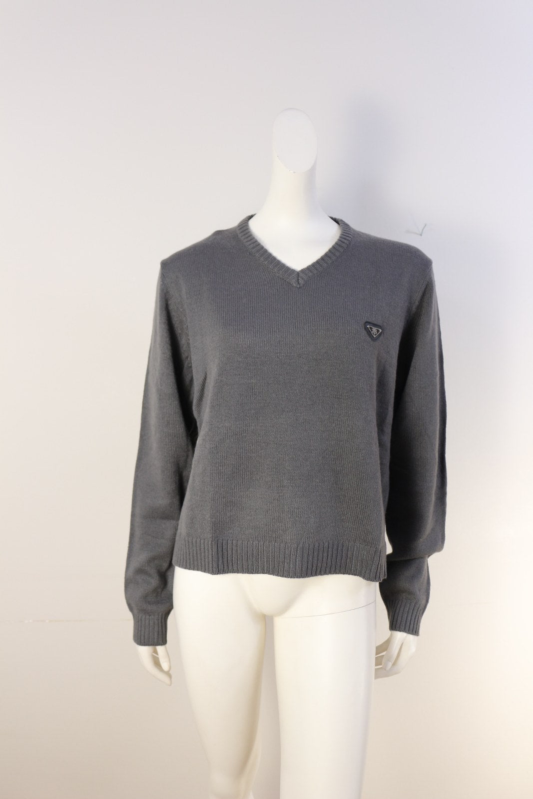 Pull Bill Tornade gris à col V avec écusson triangle sur la poitrine, porté sur mannequin – Frippin'Dealz