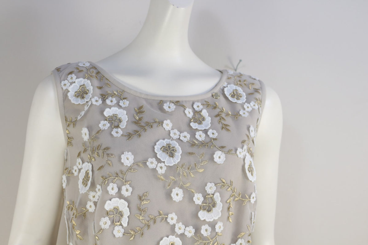 Détail de la broderie florale blanche et dorée sur le buste de la robe Kitana beige – Frippin'Dealz