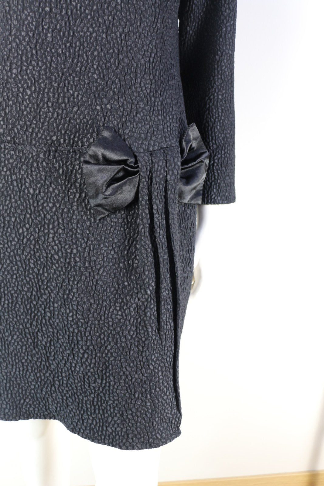 Gros plan sur le tissu texturé et le nœud satiné de la robe Marisis noire – Frippin'Dealz