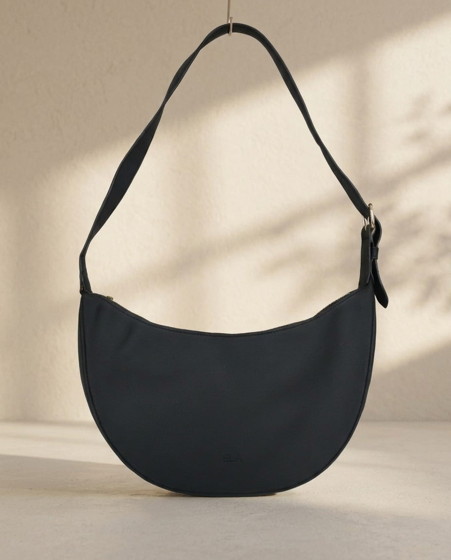 Sac demi-lune Ela noir avec bandoulière réglable suspendu – Frippin'Dealz – photo retouchée par IA