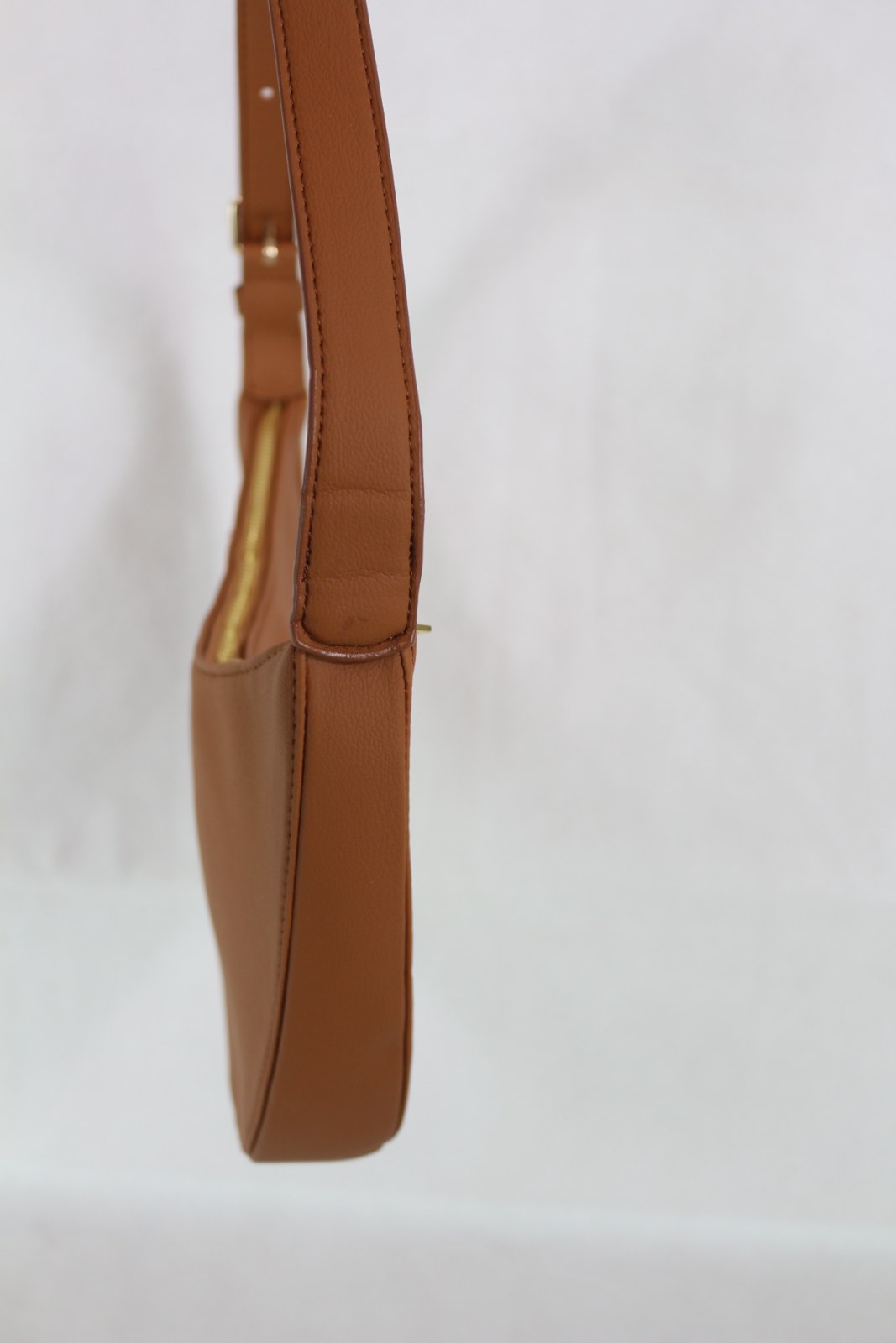 Détail de la boucle dorée et des trous de réglage de la bandoulière du sac ELA camel – Frippin'Dealz